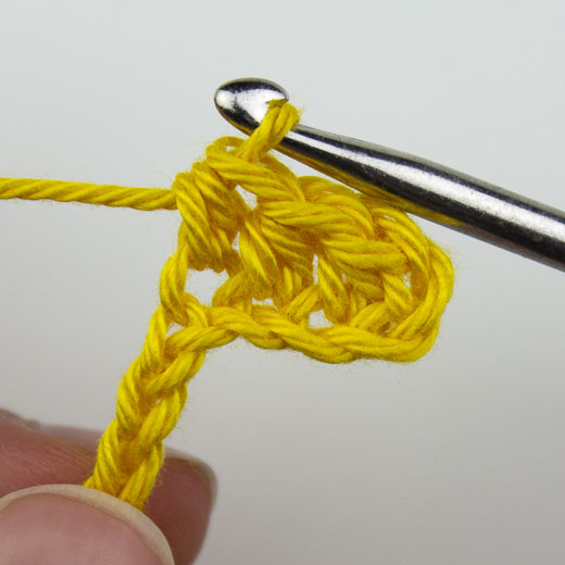 halbe Stäbchen in die Luftmaschen der Vorreihe häkeln